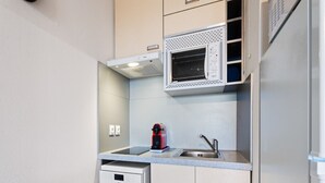 A compact kitchen with a built-in microwave, a coffee machine, and a dishwasher. - Apartment Near the Center of Grasse (Grasse)
