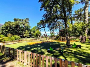 A playground with swings, a slide, and a seesaw.