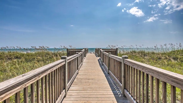 A wooden boardwalk leading to the beach with railings on both sides. - Luxury 3BR Golf Resort Condo With Digital Concierge, Pool, Near Beach (Myrtle Beach)
