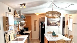 Una cocina moderna con comedor, armarios de madera y un sofá color turquesa.