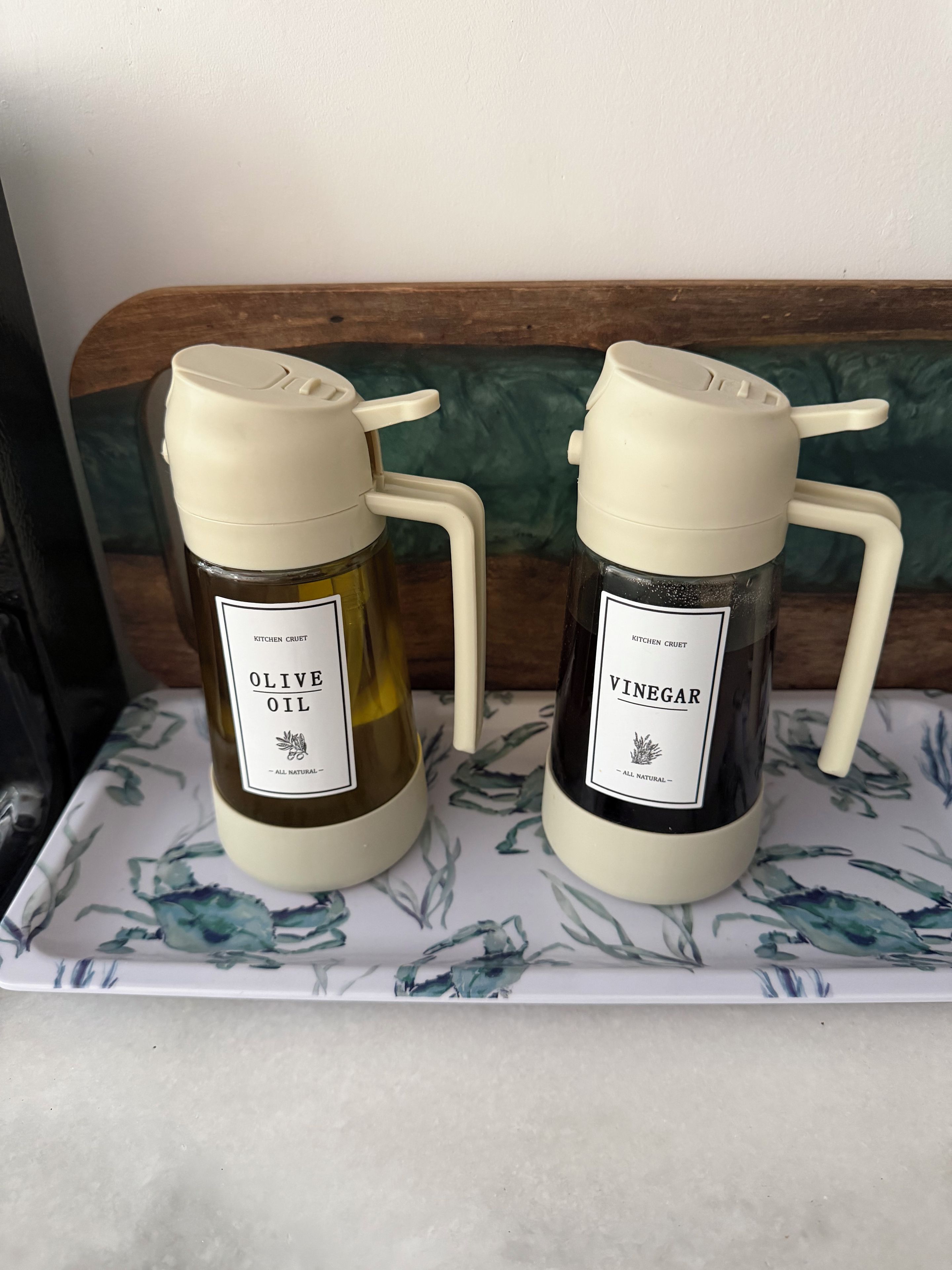 Two kitchen utensils with labels on a floral-patterned tray.