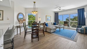 Un salón amplio con mesa de comedor, sofás y un balcón con vistas.