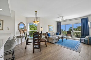 Ein geräumiger Wohnbereich mit Esstisch, Sofas und einem Balkon mit Blick.