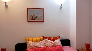 Un dormitorio con cama, almohadas, un cuadro y lámparas de noche.