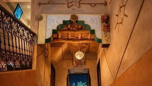 A corridor with a wooden ceiling, a star-shaped decoration, and a hanging light fixture. - dar moha dades (Ait Sedrate Jbel El Soufla)