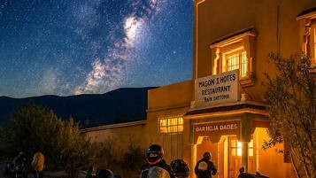 Un bâtiment avec une enseigne indiquant « Magon I Hotels Restaurant Bain Dattoma » et des motos garées devant.