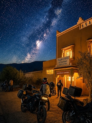 Un edificio con un letrero que dice 'Magon I Hotels Restaurant Bain Dattoma' y motocicletas estacionadas.