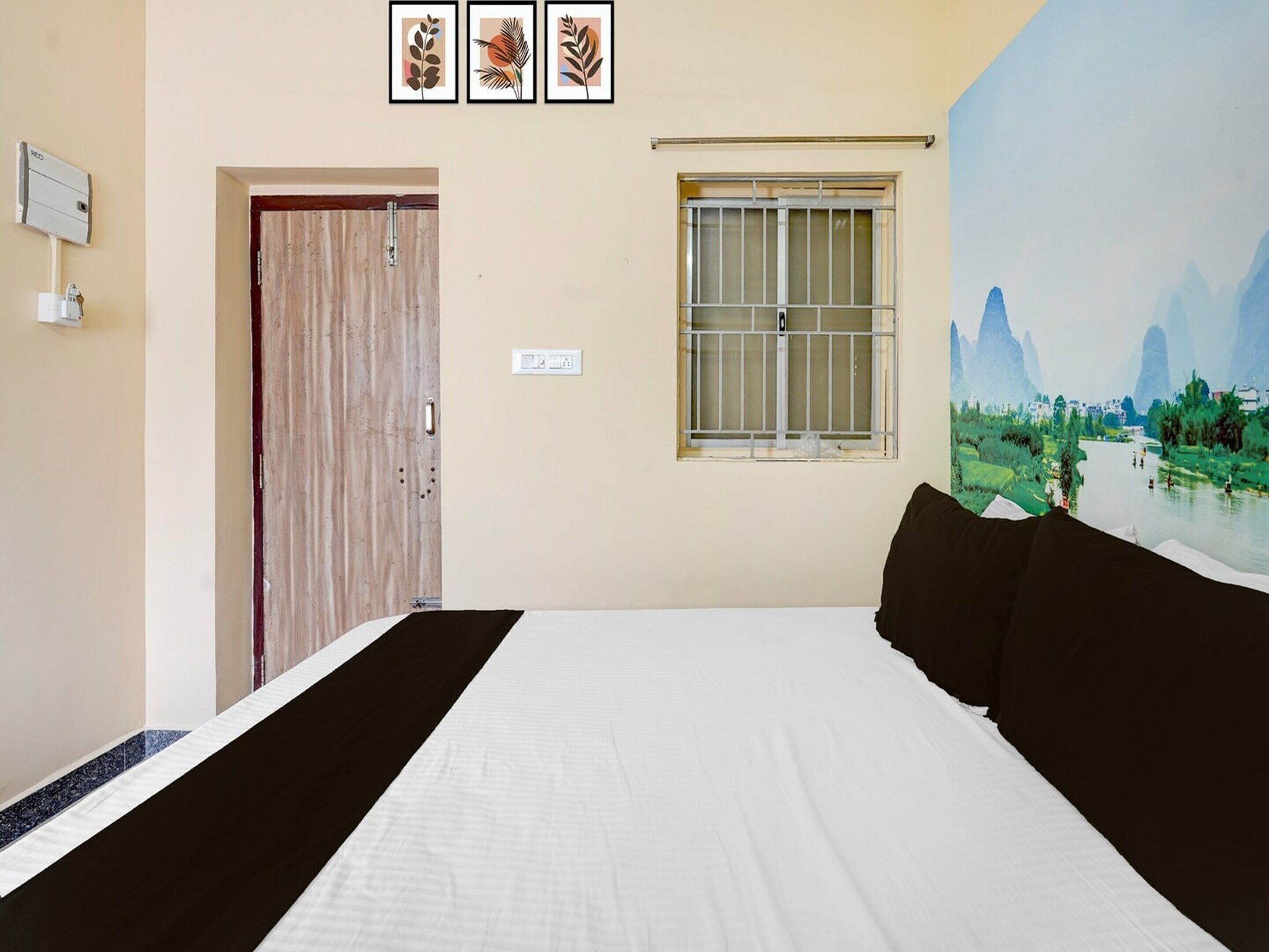 Un dormitorio con una cama, una ventana con rejas, una puerta y un cuadro en la pared.