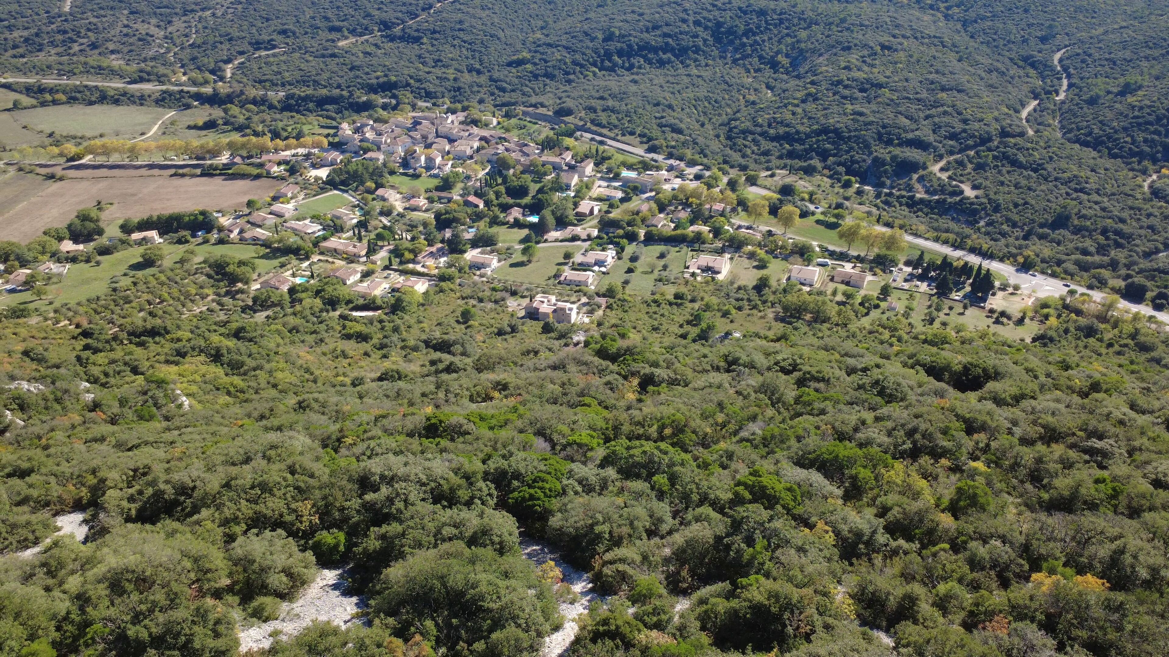 Vista aérea de uma área residencial com casas, ruas e um rio.