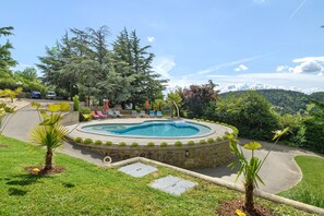 A landscaped pool area with lounge chairs, a stone pathway, and surrounding greenery. - Room “La Chambre Tom” with Shared Pool, Communal Garden and Wi-Fi (Saint-Victor)