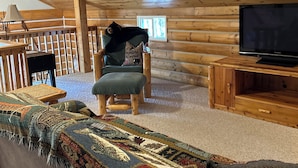 A wooden cabin interior with a cozy seating area, a television, and a window. - Cozy lake cabin in Crosslake with a fireplace, perfect for relaxing getaways. (Crosslake)