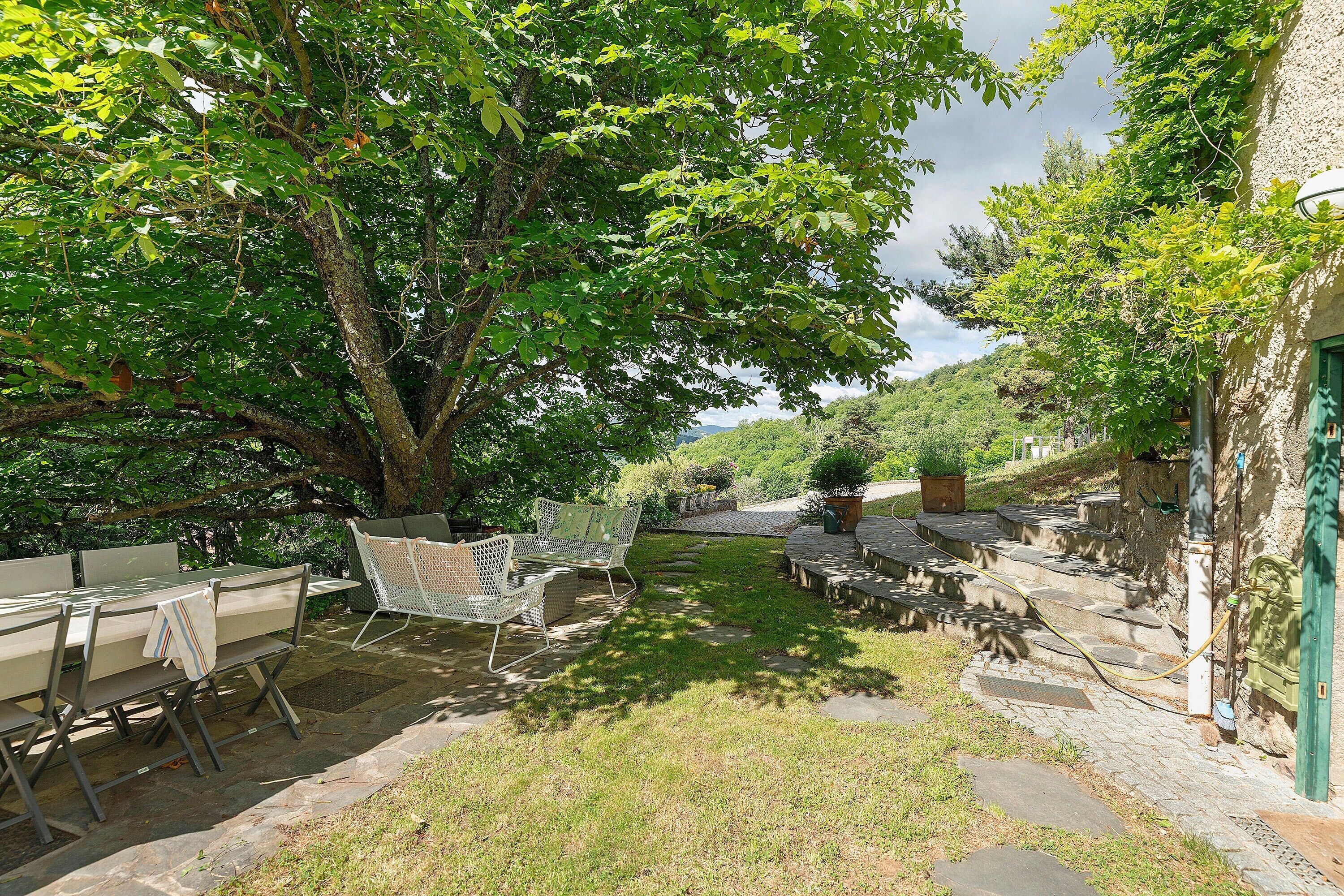 Une terrasse extérieure avec des marches en pierre, une table et des chaises.
