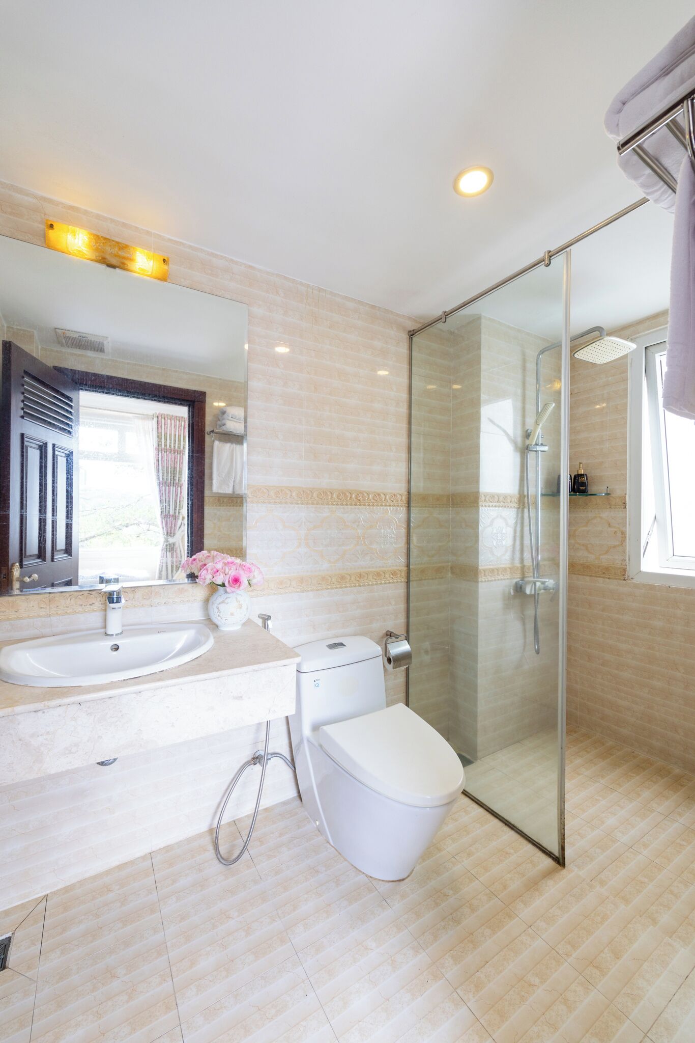 A modern bathroom with a glass-enclosed shower, dual sinks, and a toilet.