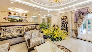 A luxurious interior with a grand chandelier, elegant furniture, and a large painting on the wall. - Hoa Sen Vang (Xuan Huong - Da Lat)