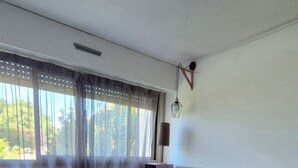 Een slaapkamer met een groot bed, een nachtkastje, een lamp en een raam met gordijnen.