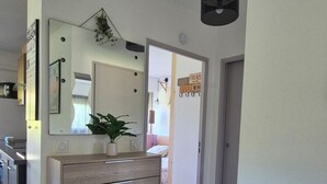 Een moderne keuken met een houten kast, een bloempot en een spiegel.