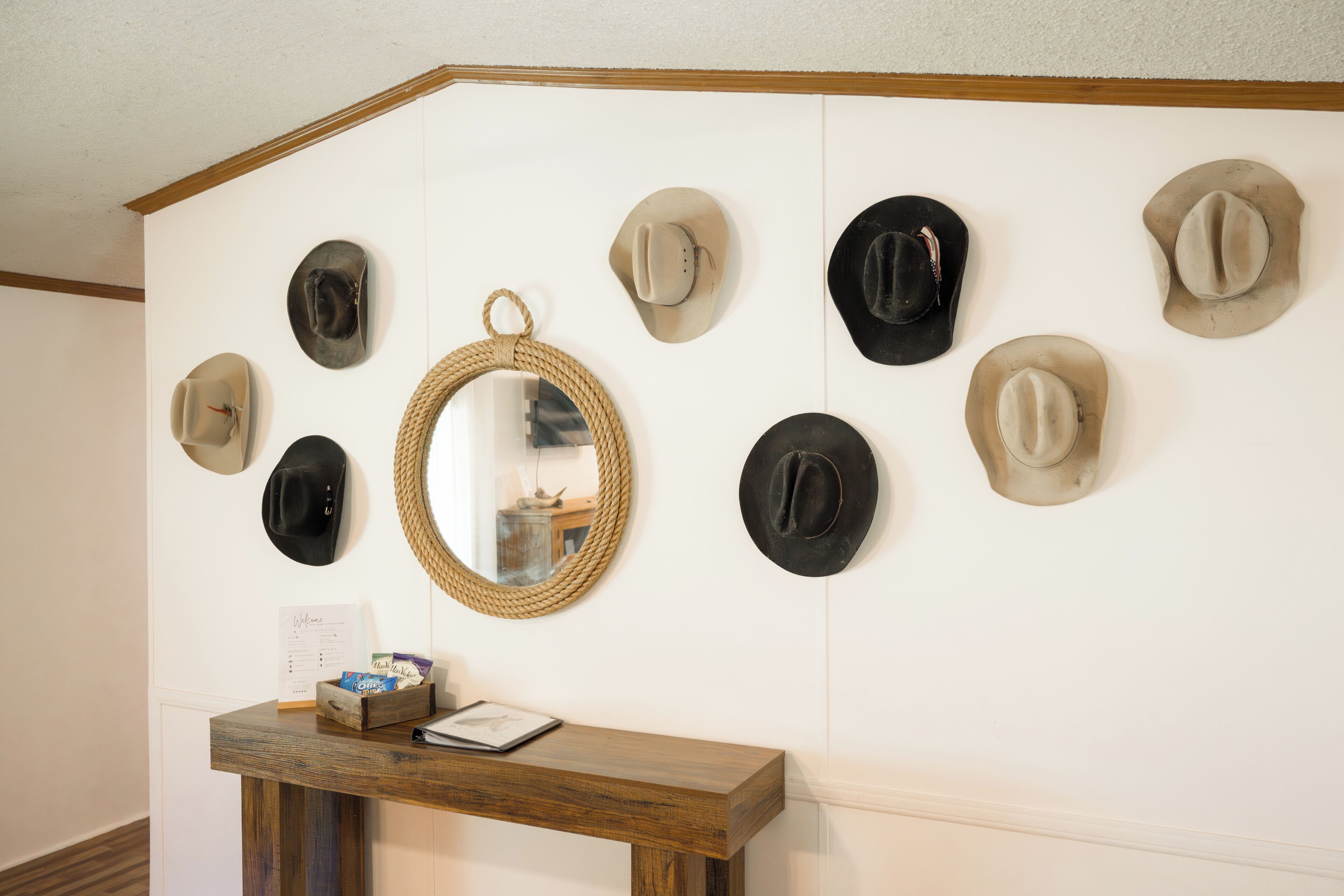 A wall with multiple hats and a mirror.