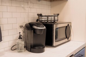 A coffee maker, a water dispenser, and a microwave on a kitchen counter. - Winchester KS Farmhouse Near KC - 3BR Country Home (Winchester)