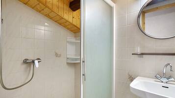A bathroom with a shower, a sink, and a mirror.