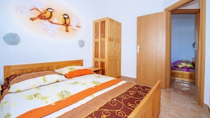 Un dormitorio con cama, armario de madera y puerta que da a otra habitación.