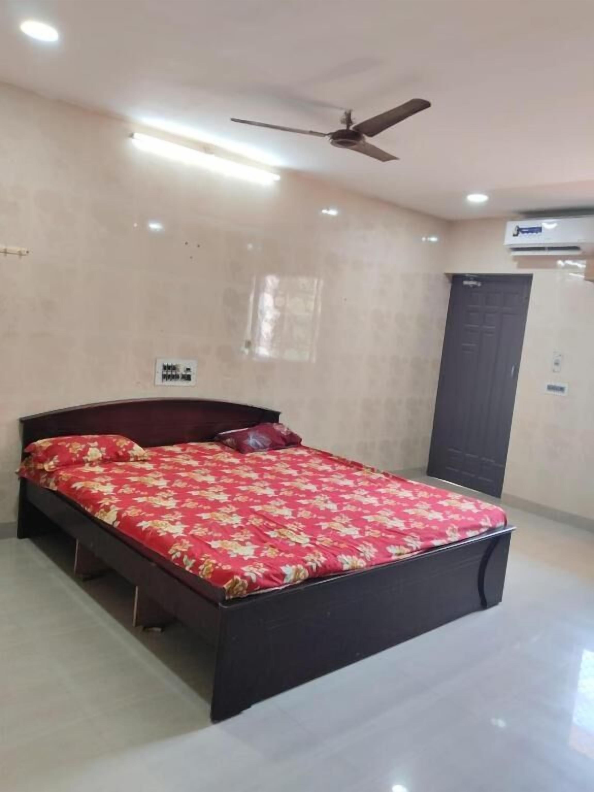 Quarto com cama, ventilador de teto e ar condicionado.