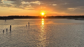 A sunset over a calm body of water with a rocky foreground.