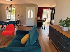 A living room with a sofa, a dining area with a table and chairs, and a kitchen area with cabinets and a countertop. - Villa with large terrace and garden in Angoulins (Angoulins)