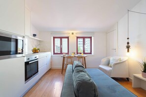 Eine kleine Küche mit Mikrowelle, Backofen und einem Essbereich mit Tisch und Stühlen.