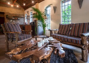 Ein rustikales Interieur mit Holzzimmermöbeln, einem Couchtisch und einem Sofa mit gestreiften Kissen.