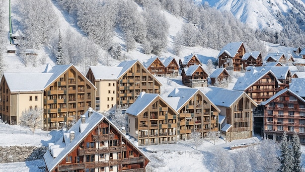 A snow-covered mountain resort with wooden cabins and a ski slope. - Rental Near Vaujany Ski Lifts (Vaujany)