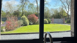 A kitchen with a window, a sink, and a hanging light fixture. - Le pressoir, calm and nature - 5min Honfleur (Équemauville)