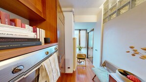Una cocina estrecha con armarios de madera, una estufa y un comedor con una silla y mesa.