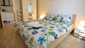 Un dormitorio con cama, mesita de noche, lámpara y armario.