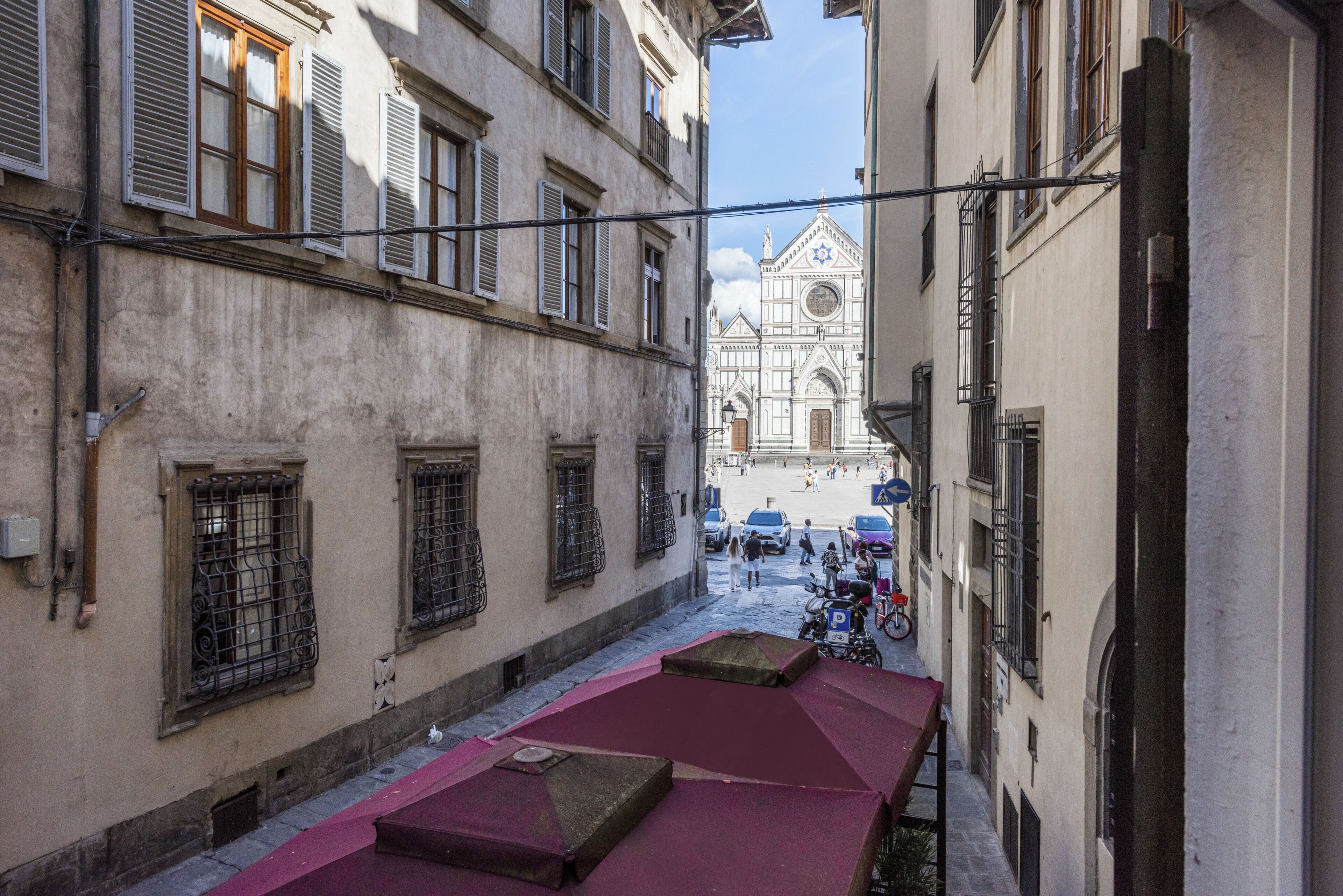 A narrow street with buildings, a church, and a bicycle.