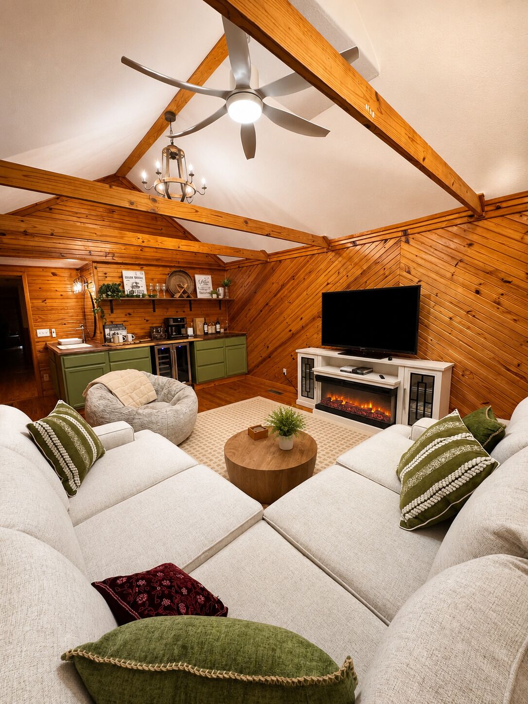 A cozy loft-style living room with a fireplace, a television, and a dining area.