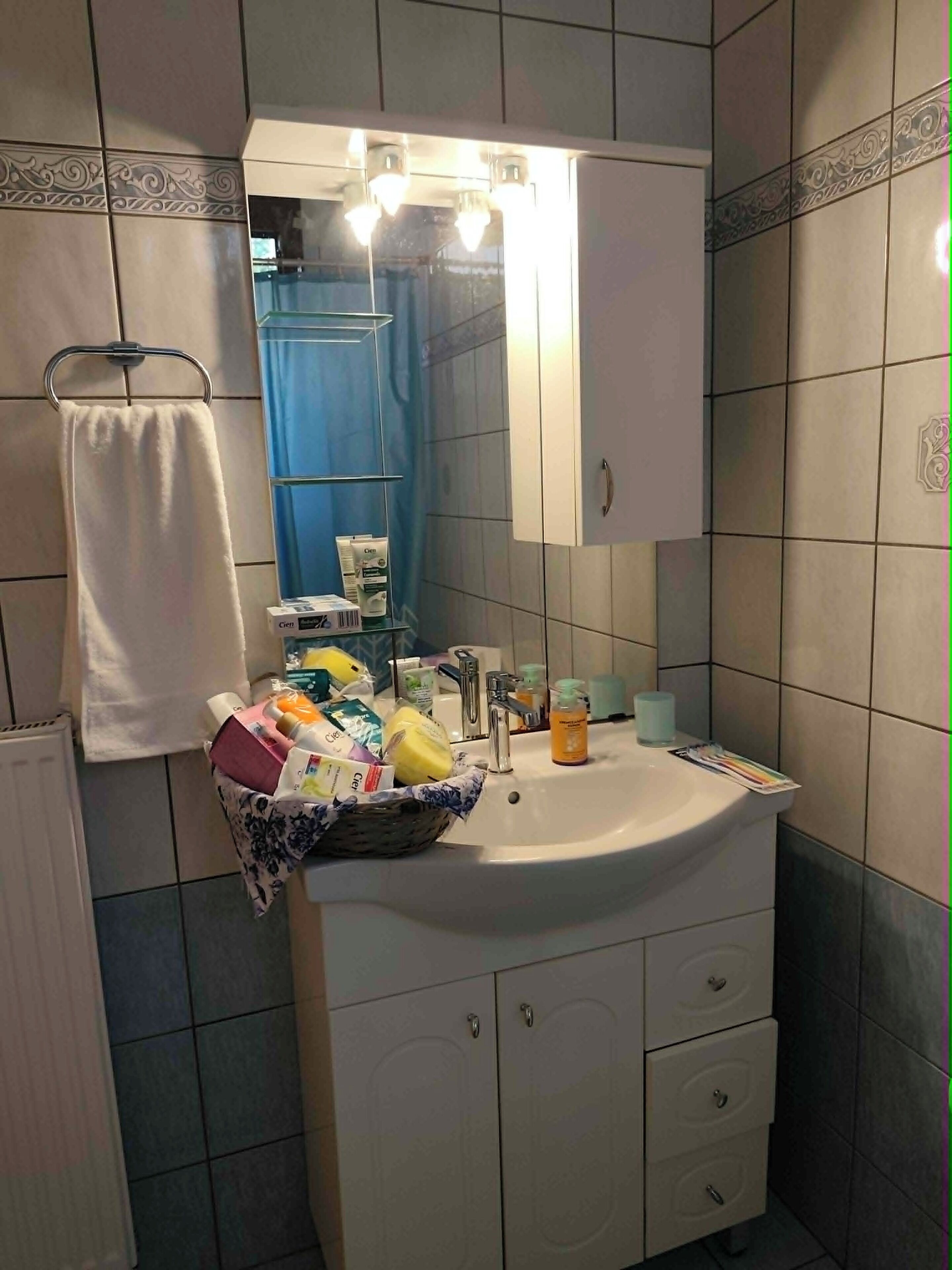 A bathroom with a sink, mirror, and toiletries.