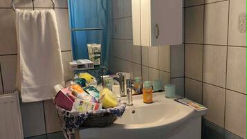 A bathroom with a sink, mirror, and toiletries.