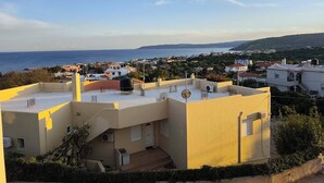 A residential area with buildings, a clear sky, and a distant view of the sea. - Άνετος οικογενειακός χώρος στην Αγία Ερμιόνη Χίου λίγα λεπτά από την παραλία! (AGIA ERMIONI)