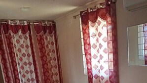 Un dormitorio con cama, cortinas y una ventana.