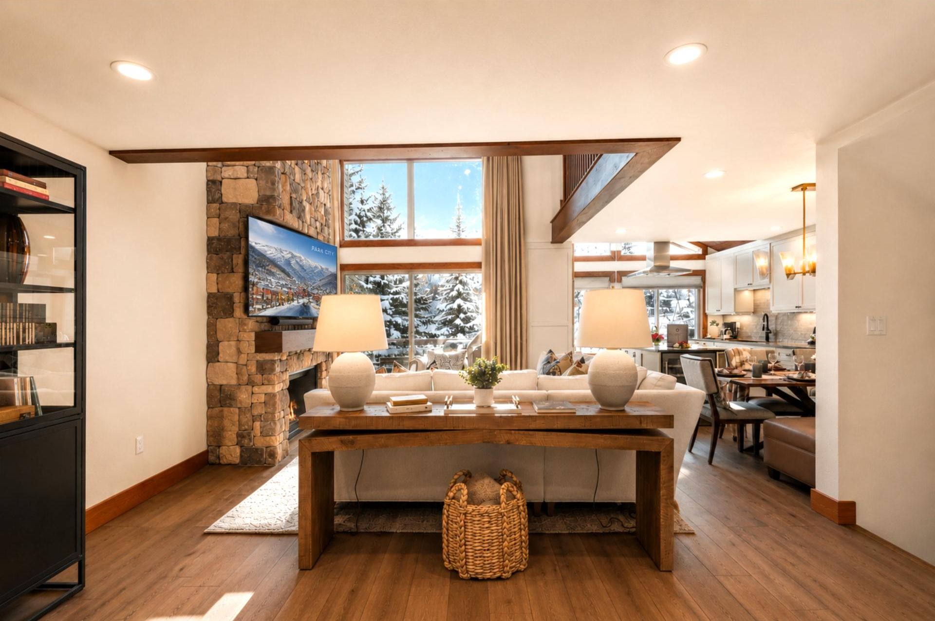 Spacious lodge-inspired interior featuring stone fireplace, mountain views, and stylish dining area.