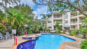 A swimming pool with a no diving sign, lounge chairs, and a building with balconies in the background. - Bliss On Beach Parade (Surfers Paradise)
