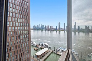 A high-rise building with a view of a river and a city skyline. - Spacious Apt in Murray Hill (New York, NY)