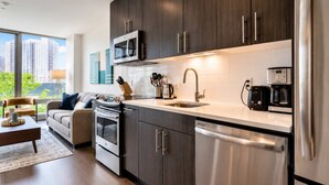 Una cocina moderna con armarios de madera oscura, electrodomésticos de acero inoxidable y un amplio ventanal con vistas a la ciudad.