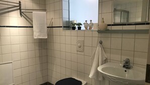 A bathroom with a toilet, sink, and a mirror. - Serene Countryside Apartment in Gjesdal, Norway (Gjesdal)