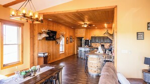 Un interior espacioso con paredes de madera, un comedor, una cocina y una zona de bar.