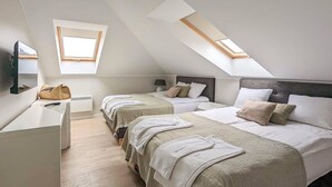 Een slaapkamer met twee bedden, een bureau en een raam.