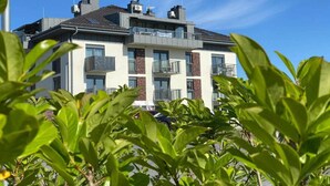 Een meerlaags woongebouw met balkons en een heldere lucht.