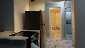 A compact kitchen with a refrigerator, oven, and a small countertop.
