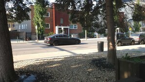 Straßenansicht eines Gebäudes mit roter Backsteinfassade und weißer Tür.