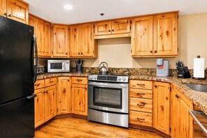 A kitchen with wooden cabinets, a stainless steel refrigerator, a microwave, an oven, and a coffee maker. - Spacious 3-Bedroom Townhome in the Prospector Neighborhood w/ Private Hot Tub! CCT-2180 by KBM (Park City)